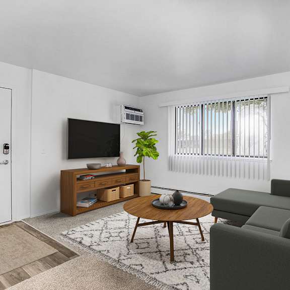 Thumbnail 5 of 13 A living room with a grey couch, a coffee table, a television, and a rug at Brookside Apartments, Springfield