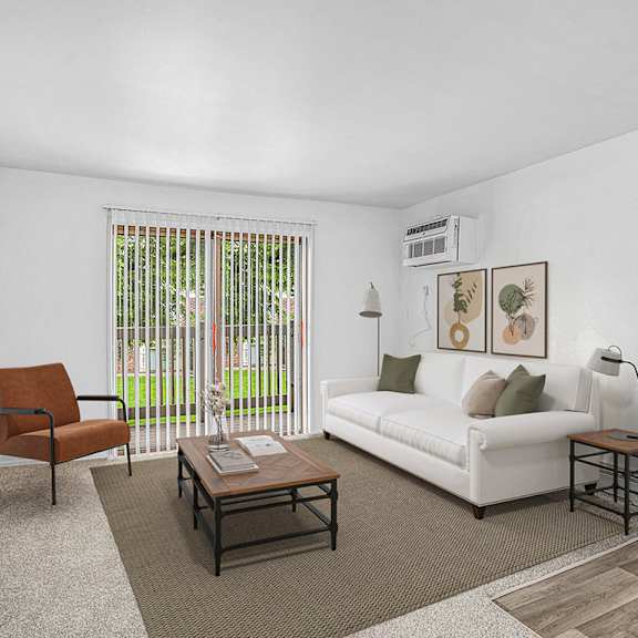 Thumbnail 3 of 13 A living room with a slider to a balcony, couch, chair, and a coffee table at Brookside Apartments, Springfield