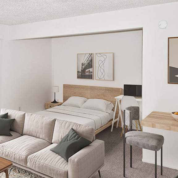 Thumbnail 5 of 11 A living room and sleeping area with a couch, a chair, and a coffee table at Brookside Apartments, Springfield