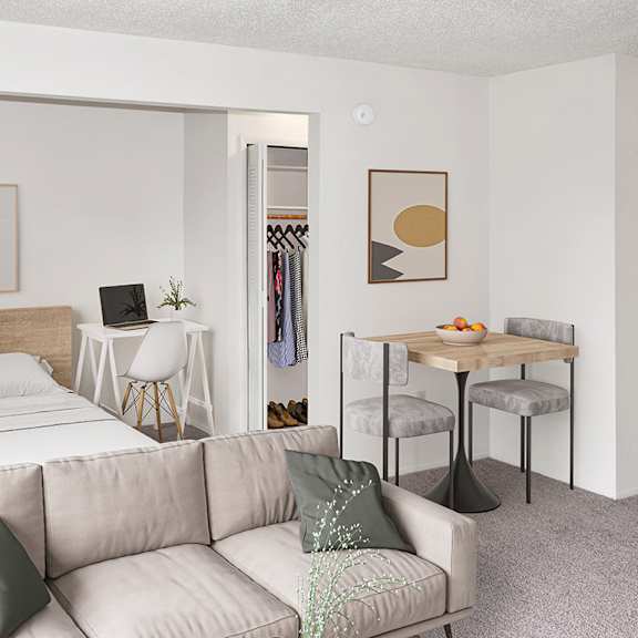 Thumbnail 6 of 11 A sleeping area with a bed and a living room with a couch, a chair, and a table at Brookside Apartments, Springfield and a clothing rack.