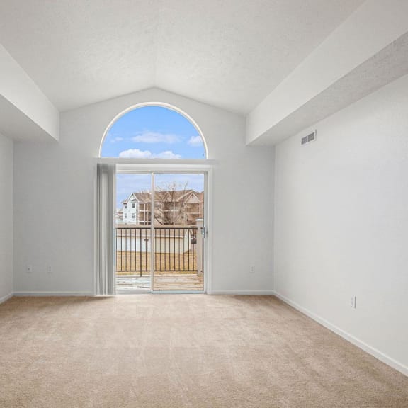 Thumbnail 4 of 12 living room with a cathedral ceiling and a door to a balcony  at Black Sand Apartment Homes, Nebraska, 68504