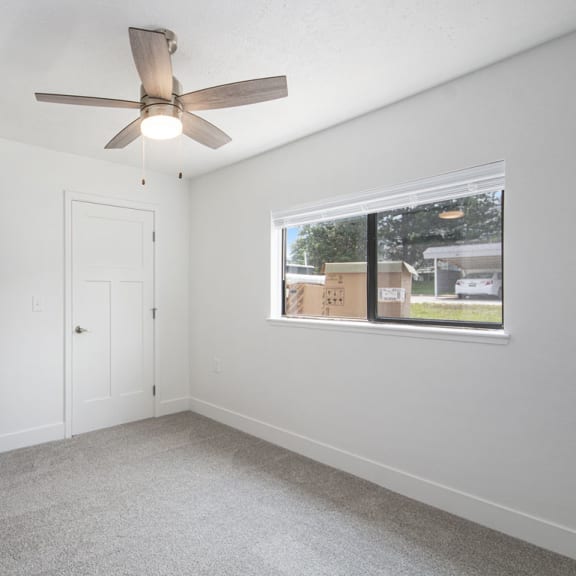 Thumbnail 9 of 15 bedroom with a ceiling fan and a window at The Crossings Apartments, Michigan, 49508