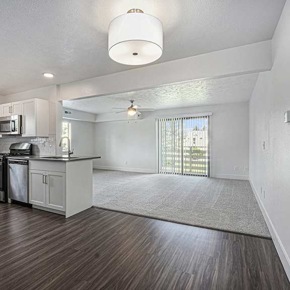 Thumbnail 4 of 14 A kitchen with white cabinets and a hard surface floor at Byron Lakes Apartments, Michigan, 49315