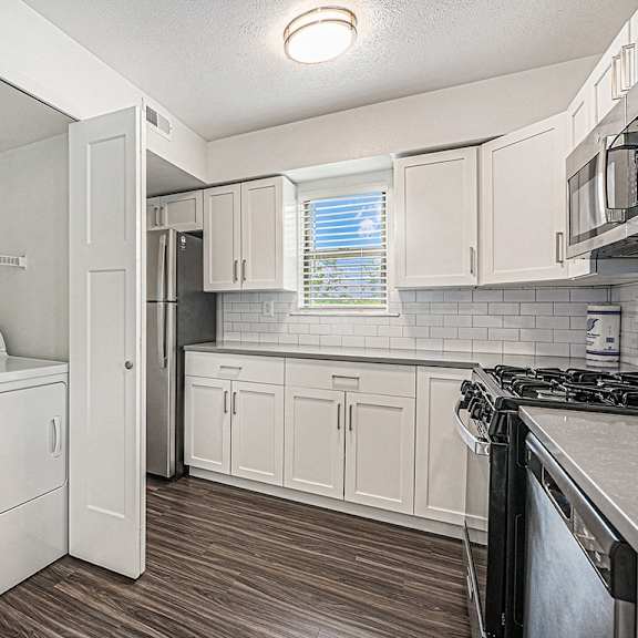 Thumbnail 10 of 14 A kitchen with a washer and dryer at Byron Lakes Apartments, Michigan, 49315