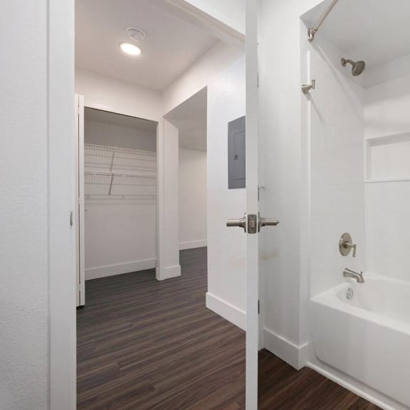 Thumbnail 15 of 19 a white bathroom with a shower and a tub at Byron Lakes Apartments in Byron Center, MI