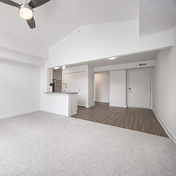 Thumbnail 6 of 19 A dining room with a cathedral ceiling, ceiling fan and a carpeted floor at Byron Lakes Apartments in Byron Center, MI