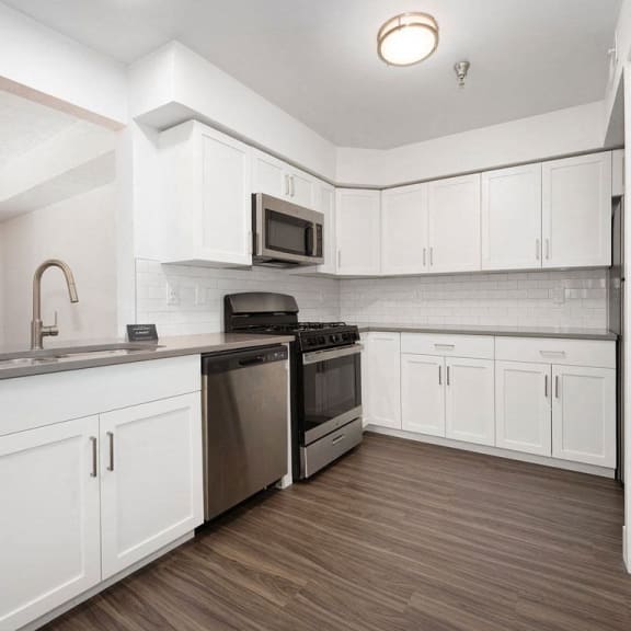 Thumbnail 12 of 19 a kitchen with white cabinets and stainless steel appliances at Byron Lakes Apartments in Byron Center, MI