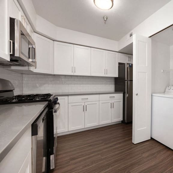 Thumbnail 13 of 19 a kitchen with a washer and dryer at Byron Lakes Apartments in Byron Center, MI