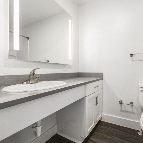 Thumbnail 15 of 24 a renovated bathroom with a sink toilet and a mirror at Byron Lakes Apartments in Byron Center, MI