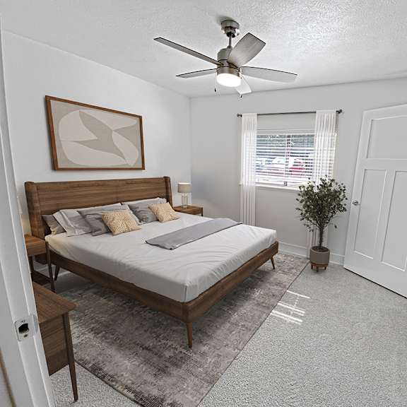 Thumbnail 14 of 17 A bedroom with a bed, a ceiling fan, and a walk-in closet at Byron Lakes Apartments, Michigan, 49315