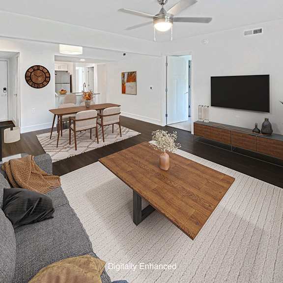 Thumbnail 5 of 24 A living room with a grey couch, hard surface flooring, and a ceiling fan at Byron Lakes Apartments in Byron Center, MI