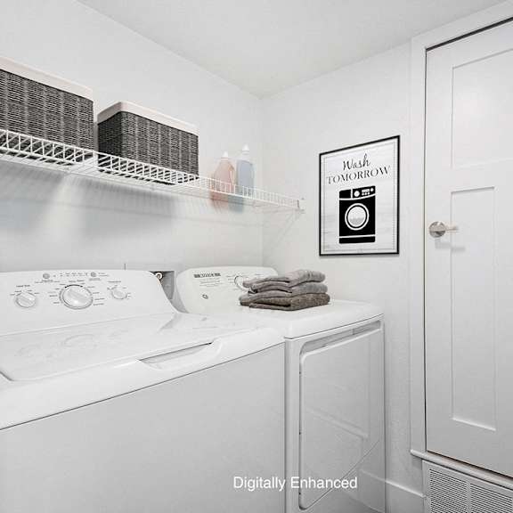 Thumbnail 14 of 24 a laundry room with a washer and dryer and a white door at Byron Lakes Apartments in Byron Center, MI