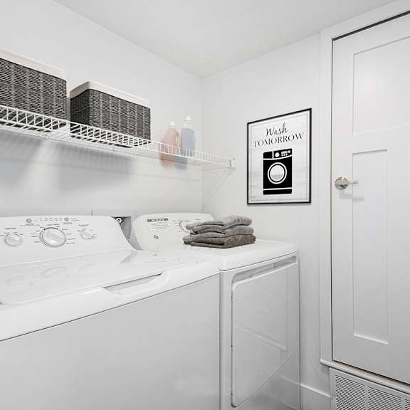 Thumbnail 11 of 17 A laundry room with a washer and dryer at Byron Lakes Apartments, Michigan, 49315