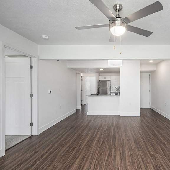 Thumbnail 4 of 24 A living room with a ceiling fan and hard surface flooring at Byron Lakes Apartments, Michigan, 49315