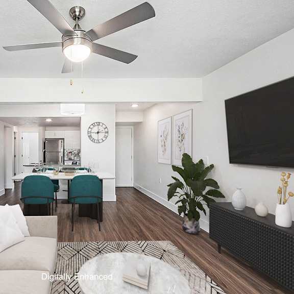 Thumbnail 3 of 24 A living room with a white couch and a ceiling fan at Byron Lakes Apartments in Byron Center, MI