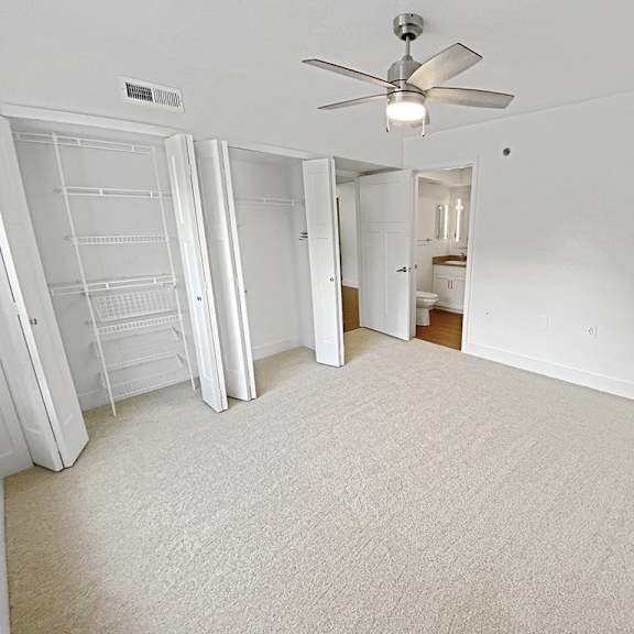 Thumbnail 22 of 24 A bedroom with a ceiling fan and carpeted floor at Byron Lakes Apartments, Michigan, 49315