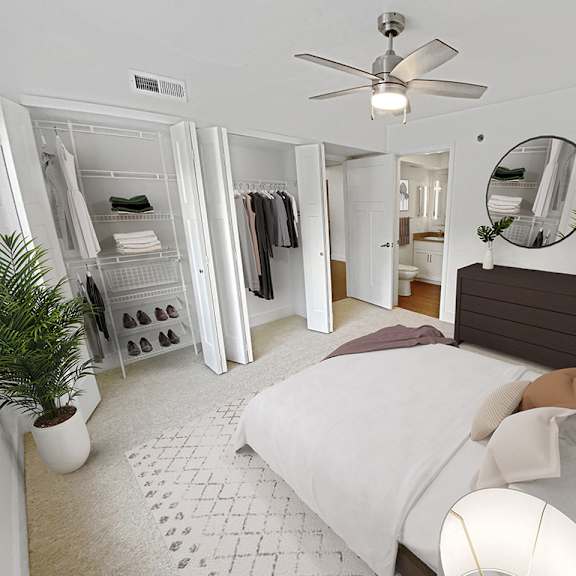 Thumbnail 16 of 17 A master bedroom with a bed, a ceiling fan, a large closet and attached bath at Byron Lakes Apartments, Michigan, 49315