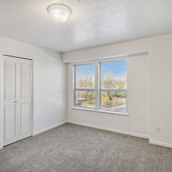 Thumbnail 13 of 14 Bedroom with large windows and a door to a closet at Canal 2 Apartments in Lansing, MI