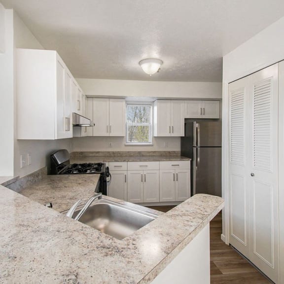 Thumbnail 7 of 14 End style kitchen with white cabinets and a window at Canal 2 Apartments in Lansing, MI