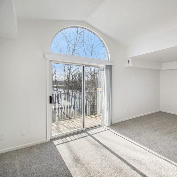 Thumbnail 4 of 14 living room with a cathedral ceiling and an  extra window at Canal 2 Apartments in Lansing, MI