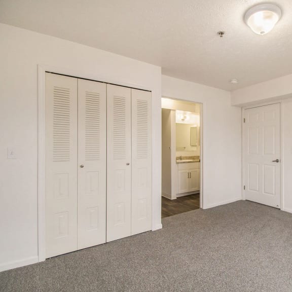 Thumbnail 14 of 16 bedroom with white closets and an attached bath at Canal 2 Apartments in Lansing, MI