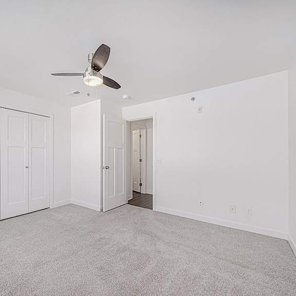 Thumbnail 17 of 18 A bedroom with a ceiling fan and carpeted floor at Chase Creek Apartment Homes, Huntsville, 35811
