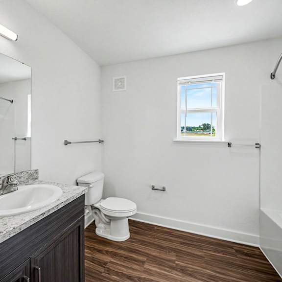 Thumbnail 11 of 13 A bathroom with a toilet, sink, window and bathtub at Chase Creek Apartment Homes, Huntsville, AL, 35811