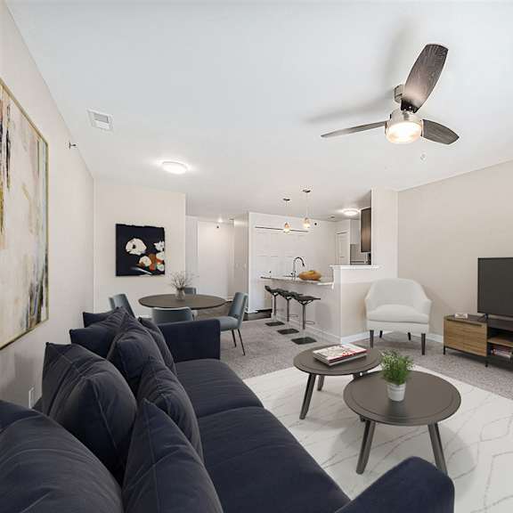 Thumbnail 3 of 14 A living room with a dark blue sofa and a ceiling fan at Chase Creek Apartment Homes, Huntsville, 35811