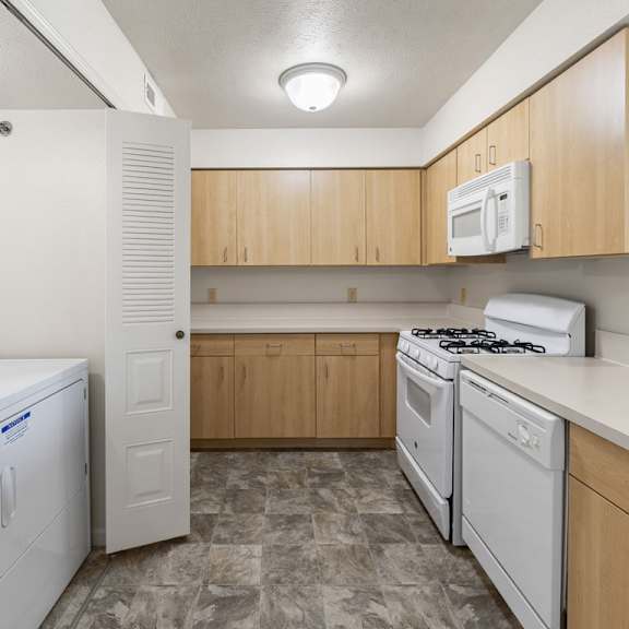 Thumbnail 3 of 6 A kitchen with a washer and dryer at Colonial Pointe at Fairview Apartments, Bellevue, NE, 68123