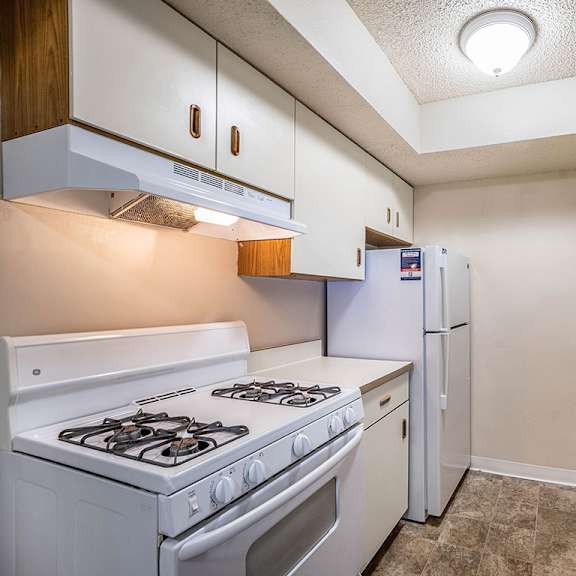 Thumbnail 9 of 14 A kitchen with a white stove and refrigerator at Concord Place Apartments, Kalamazoo, MI, 49009