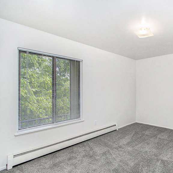 Thumbnail 15 of 15 A spacious bedroom with a window and carpeted floor at Concord Place Apartments, Kalamazoo, MI