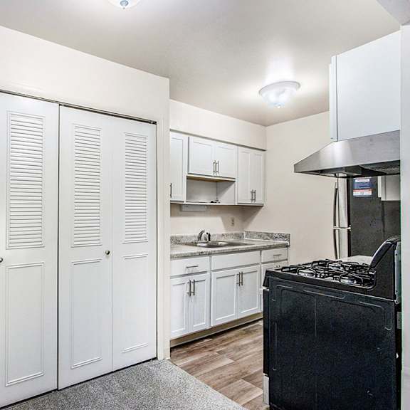 Thumbnail 7 of 15 An upgraded kitchen with white cabinets and stainless steel appliances at Concord Place Apartments, Kalamazoo, MI