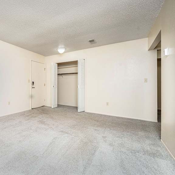 Thumbnail 6 of 14 A living room with a carpeted floor and a closet at Concord Place Apartments, Kalamazoo, MI, 49009