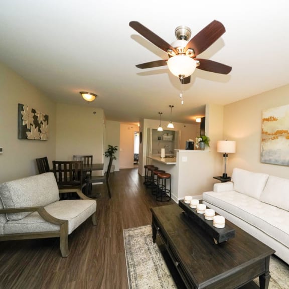 Thumbnail 7 of 15 A living and dining room with a ceiling fan at Copper Creek Apartment Homes, Maize, KS, 67101