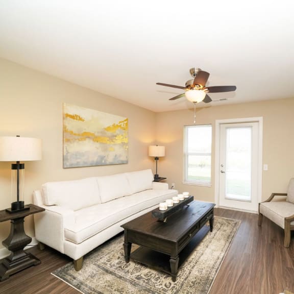 Thumbnail 5 of 15 A living room with hard surface flooring and access to a patio at Copper Creek Apartment Homes, Kansas, 67101