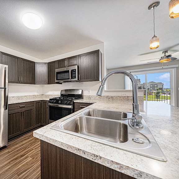 Thumbnail 9 of 15 A modern kitchen with a stainless steel refrigerator at Copper Creek Apartment Homes, Maize