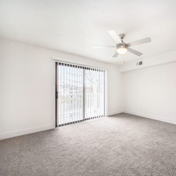 Thumbnail 3 of 8 Large living room with ceiling fan at The Crossings Apartments, Grand Rapids, MI, 49508