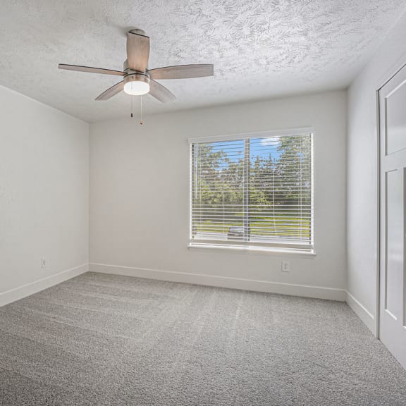 Thumbnail 12 of 13 large bedroom with a ceiling fan and a window at The Crossings Apartments, Michigan, 49508