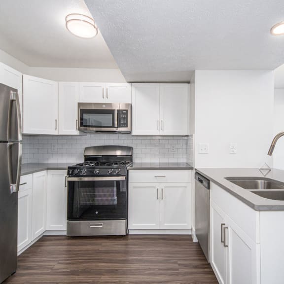 Thumbnail 6 of 15 kitchen with white cabinets and stainless steel appliances at The Crossings Apartments, Michigan, 49508