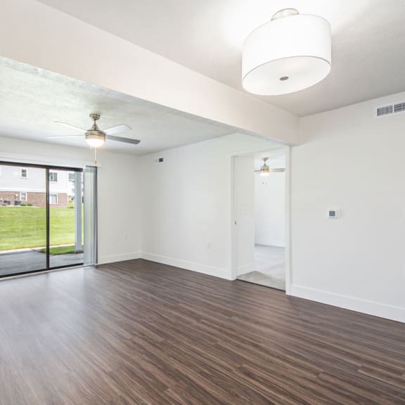 Thumbnail 5 of 15 living room with hard surface flooring and a sliding glass door to a patio at The Crossings Apartments, Michigan, 49508