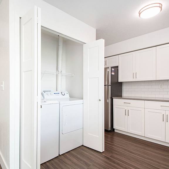 Thumbnail 11 of 16 A laundry room with a full-size washer and dryer at The Crossings Apartments, Grand Rapids