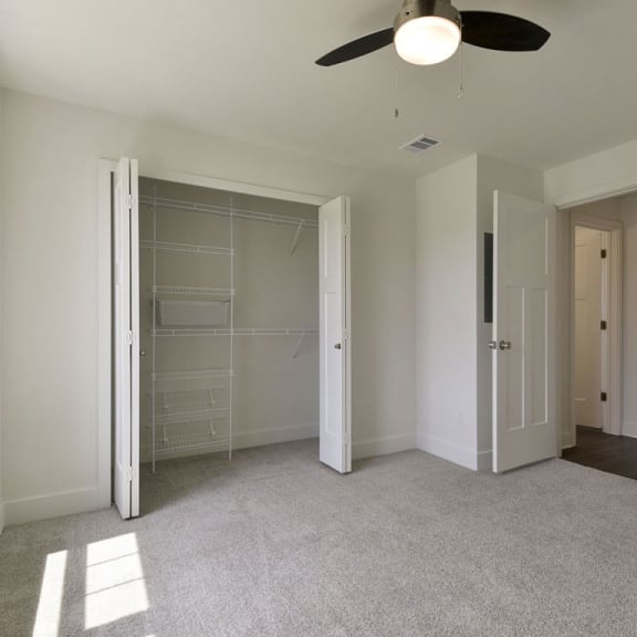 Thumbnail 12 of 12 A bedroom with a large closet with wardrobe organizers at Dodson Pointe Apartment Homes, Rogers