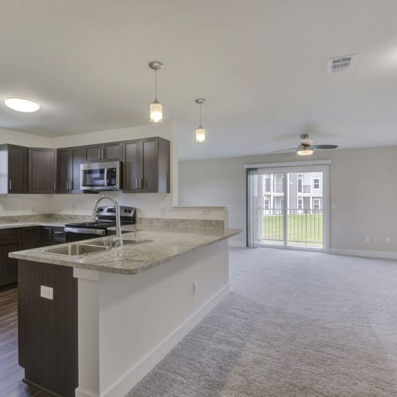 Thumbnail 3 of 12 End style dining and living room leading to a modern kitchen at Dodson Pointe Apartment Homes, Arkansas, 72758
