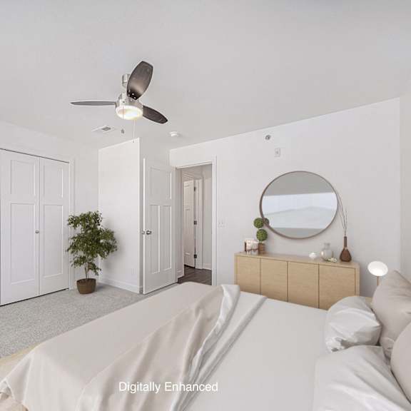 Thumbnail 13 of 14 A bedroom with a bed, dresser, mirror, and a ceiling fan at Dodson Pointe Apartment Homes, Rogers