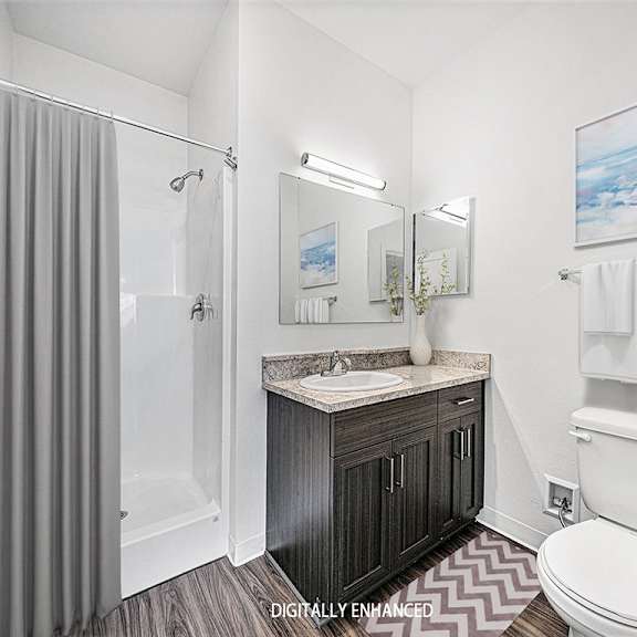 Thumbnail 13 of 13 A bathroom with a sink, toilet, and shower at Dodson Pointe Apartment Homes, Rogers