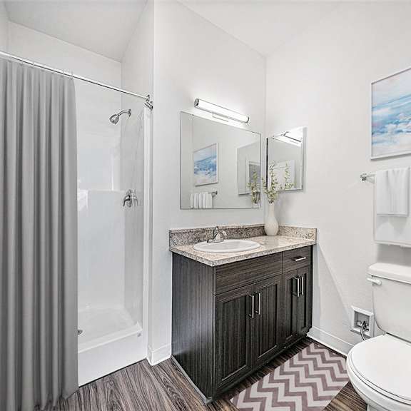 Thumbnail 11 of 11 A bathroom with a sink, toilet, and shower at Dodson Pointe Apartment Homes, Rogers