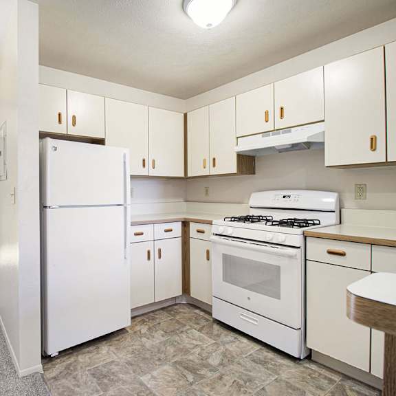 Thumbnail 10 of 16 A kitchen with white refrigerator and stove at Dupont Lakes Apartments in Fort Wayne, IN