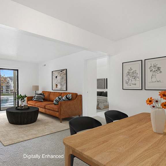 Thumbnail 4 of 13 A living room with a brown sofa and a wooden table at Dupont Lakes Apartments in Fort Wayne, IN