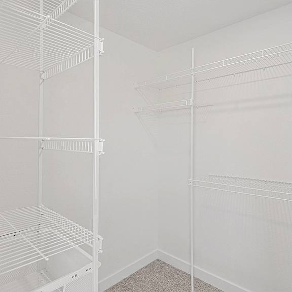 Thumbnail 14 of 18 Bedroom with walk in closet with wardrobe organizers at Eagle Ridge Apartment Homes, Traverse City