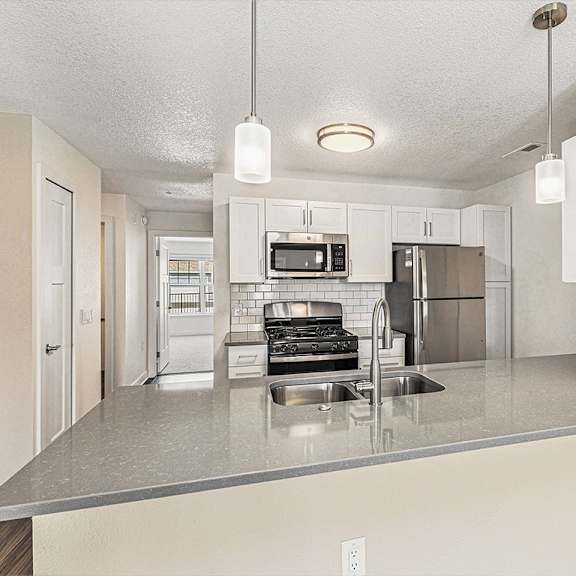 Thumbnail 8 of 18 Living room with carpet leading to kitchen at Eagle Ridge Apartment Homes,  Michigan 49685